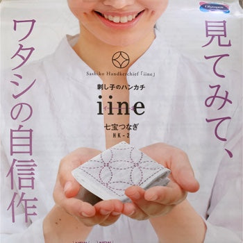 image of the cover of an Olympus sashiko kit that says iine, the photo depicts a person holding a folded handkerchief with sashiko stitching in her hands